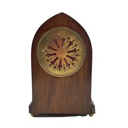 An Edwardian mahogany veneered Lancet cased mantle clock with oval inlay and stringing, on a moulded plinth raised on four bun feet, eight-day French rack striking movement, striking the hours and half hours on a coiled gong, two-part dial with a gilt centre, enamel chapter ring with roman numerals and minute markers, steel fleur di lis hands within a beaded cast bezel with a flat bevelled glass. With Pendulum



