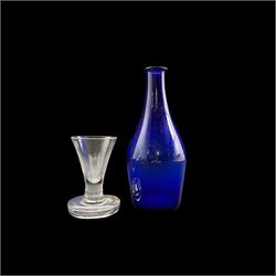 Early 19th century firing glass with trumpet shape bowl and thick circular foot H10cm and a 19th century blue glass bottle H19cm