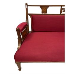 Late Victorian rosewood settee, inlaid with cartouche motifs with trailing bell flowers, upholstered in red fabric, on square taping supports with spade feet