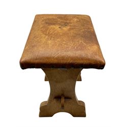 'Gnomeman' oak stool, shaped end supports joined by pegged stretcher, the seat upholstered in leather with studs, carved with gnome signature, by Thomas Whittaker of Littlebeck