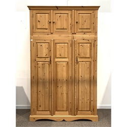 Pine triple wardrobe, with three cupboards over three full length cupboards enclosing interior fitted for hanging and with shelves, raised on shaped plinth base, W144cm, H239cm, D65cm