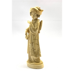 Japanese Meiji carved ivory Okimono of a Bijin, Tokyo School, standing wearing elaborately decorated kimono incised with birds and waves, holding a fan in her hand, signed beneath, H23.5cm 