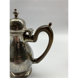 Late Victorian Britannia standard hammered silver baluster hot milk jug with domed cover, stained wooden handle and short pedestal foot H16cm London 1897 Maker Joseph Heming 9.7oz gross  