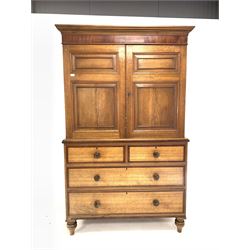 Late Georgian oak press, mahogany banded frieze over two panelled doors enclosing two shelves, two short and two long drawers under, raised on turned supports W131cm, H210cm, D51cm