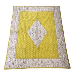 Vintage quilted patchwork bed cover, with mustard yellow border and matching central lozenge medallion on a pink and white floral ground, the reverse with a similar design, 170cm x 135cm