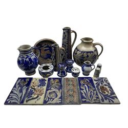 Collection of German and Continental salt glazed stoneware including two tall tapered jugs, plate, pair of candlesticks, tiles etc 