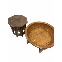 Indian hardwood octagonal occasional table, the top carved in relief with a concentric floral design, the folding base with pierced fretwork detail (W53cm) together with a large hardwood and brass banded bowl on a folding cruciform base (D79cm) 