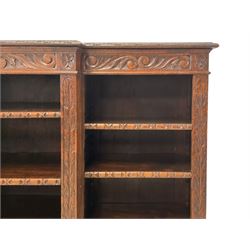 Carolean Revival - Victorian carved oak open breakfront bookcase, the edge carved with foliate detail over a banded frieze with scrolling foliage carvings, fitted with nine adjustable shelves, each column flanked by acanthus decorated uprights, the shelf front edges carved with egg and dart motifs