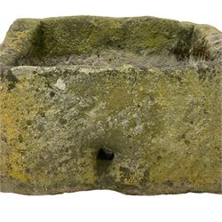 Weathered sandstone trough, sloped form with roughly tooled exterior and deeply hewn centre