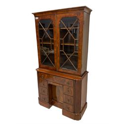 19th century figured walnut bookcase on cabinet, two astragal glazed doors with surrounding feather stringing enclosing three adjustable shelves over three correspondence drawers with turned bone handles, the collector's kneehole base fitted with eight assorted drawers, two with removable facias revealing small collectors drawers with coin trays, central recessed cupboard enclosing shelf, all flanked by quarter-canted fluted pilasters, on shaped skirted base