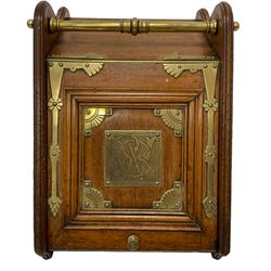 Late 19th century oak and brass mounted coal box with shovel, panelled hinged lid with central monogrammed brass plaque and geometric design spandrels, moulded and shaped end supports, with metal liner