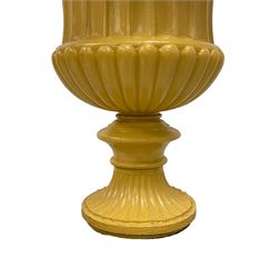 Campana shaped urn on pedestal, the urn with egg and dart moulded rim over fluted body with gadrooned underbelly, on stepped and moulded footed base, on a black painted pedestal of square tapered form