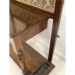 Edwardian oak hallstand, the back with broken arch pediment and spindle gallery over four brass coat hooks, an octagonal bevel edge mirror and tile inserts, over one drawer raised on turned supports united by under tier fitted with two drip trays, W103cm, H207cm, D40cm