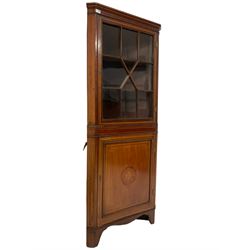 Edwardian inlaid mahogany corner cabinet, projecting cornice over astragal glazed door enclosing two shelves, the base fitted with single panelled door, the facia with foliate satinwood inlay and ebony stringing, raised on bracket feet