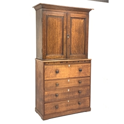 George III oak and mahogany cupboard on secretaire, projecting cornice over two panelled doors enclosing shelves, fall front secretaire drawer with fitted interior above three long drawers, W116cm, H214cm, D50cm