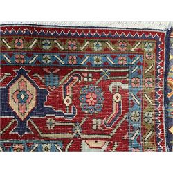 Persian Herati blue and red ground rug, the central medallion and surrounding field decorated with repeating Herati motifs, rust ground spandrels decorated with small stylised motifs, flowerhead design guard bands enclosing the band decorated with stylised plant motifs, thick woollen pile