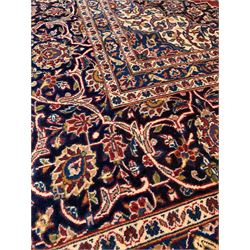 Large Kashan red ground carpet, the central field with medallion and interlaced trailing foliate enclosed by triple guarded border 291cm x 400cm