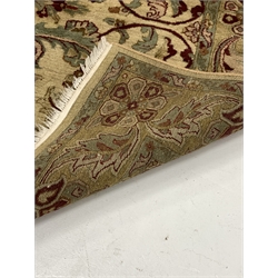 Fawn ground thick pile wool rug, the central field decorated with floral design of yellows, greens and reds, further stylised foliate to border 
