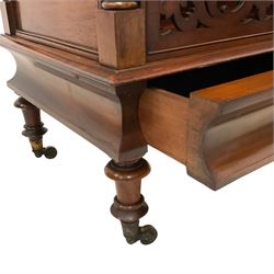 Victorian mahogany three-division Canterbury,  turned supports and finials, panelled sides and fretwork panelled front, cavetto moulded frieze with single drawer, turned feet on castors