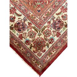 Persian Meshed golden red ground carpet, central rosette medallion in field of trailing branch and stylised plant motifs, shaped spandrels with medallions, triple band border, the main band decorated with stylised flower head motifs 