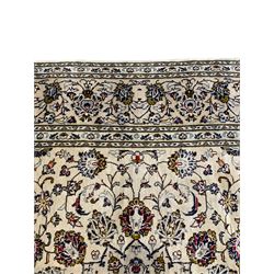 Persian Kashan ivory ground rug, the central star medallion with a surrounding ring of palmette motifs, extending into the field with branches of interlacing floral motifs and leafage, the guarded border with matched repeating foliate motifs