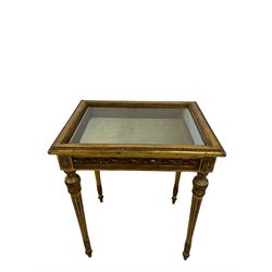 French style giltwood and gesso table vitrine or bijouterie cabinet, bevel glazed hinged lid in leaf and bead moulded frame, lined interior, the frieze panels decorated with foliage twist mouldings and flower head motifs, on turned and fluted supports decoration with foliate motifs, W61cm, H74cm, D45cm