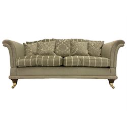 Large pair traditional design drop-arm two seat sofas, shaped back and scrolled arms, upholstered in textured pale sage fabric with striped seat cushions, raised on tapered feet with brass cups and castors