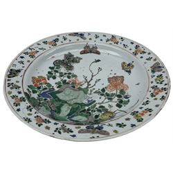 Chinese famille verte porcelain charger, Kangxi period, brightly enamelled with two butterflies in flight above chrysanthemum and peonies issuing from rockwork, the border painted with further butterflies amongst floral sprigs, artemisia leaf mark within double circles beneath, D35cm Provenance: From the Estate of the late Dowager Lady St Oswald