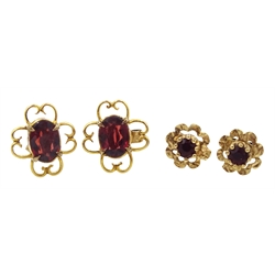 Pair of gold oval garnet stud earrings, open work design and one other similar pair, both 9ct stamped or tested