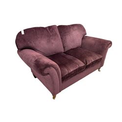 Two seat sofa upholstered in plum fabric raised turned front supports with brass castors