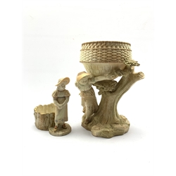 Royal Worcester blush ivory jardinière, the basket on figural support depicting young girl beside a tree, no. 1315 together with a similar fern pot no. 1242 (2)