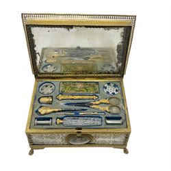 Early 19th century French Palais Royal type ormolu and mother-of-pearl musical sewing etui, the hinged cover and sides with foliate engraved mother of pearl panels and applied gilt glass domes inset with dried flowers, pierced ormolu gallery and embossed mounts, set on four acanthus and hoof feet, the velvet lined interior with 18ct gold and gold mounted utensils including thimble, pair of scissors, needle case, spike, cut glass scent bottle and bodkin mostly marked with Paris ram’s head hallmark, mother of pearl snowflake winders, two bobbins and floral embroidered pin cushion, with later two air musical movement beneath, L18cm, H9cm, D13cm Provenance: With a handwritten letter gifting the box to her niece and explaining some of it's history, dated 1908