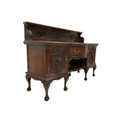 Early to mid-20th century walnut sideboard, the raised panelled back carved with geometric designs and heavily carved fruit and flower oval panels, the convex front fitted with single drawer and flanked by ornate foliate carved cupboard doors, raised on cabriole supports with moulded acanthus leaves terminating in ball and claw feet