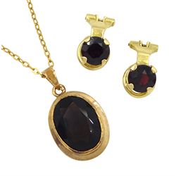 Gold oval smoky quartz pendant necklace and a pair of gold garnet clip on earrings, both 9ct 