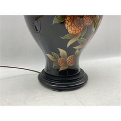 French porcelain table lamp of baluster form decorated with lychees on black ground, on ebonised wooden base H46cm