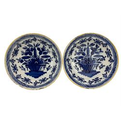 Pair 18th century Dutch Delft blue and white chargers, each painted with a central urn of flowers within foliate borders and mustard yellow rims, D35cm (2)
