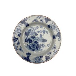 Two18th century Delft chargers and plate, one charger centrally painted with a landscape scene with rockwork, trees and birds D35cm, the other painted with Chinoiserie style flowers, and the plate, possibly Liverpool, painted in the chinoiserie style with floral sprays (3)