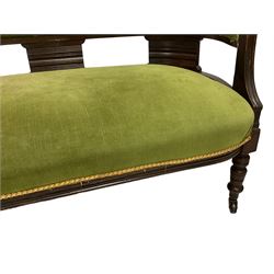 Late 19th century walnut chaise longue, upholstered in green fabric, scrolled back with carved foliate decoration, on turned feet with castors