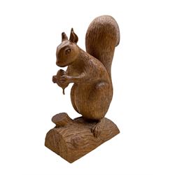 Carved oak model of a Squirrel standing on a branch holding an acorn, signed L. Johnson York EN/ 21177, H23cm