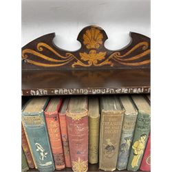 Early 20th century hanging bookshelf, the shelves decorated with brass wire motto and poker work decoration, with an assortment of cloth bound books, L59cm x H44cm