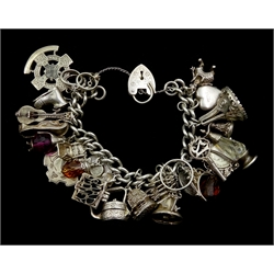 Heavy silver curb chain bracelet, with various charms including rabbit in a hut, money box teapot, guitar, clown, keys bell