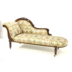 Late Victorian walnut chaise longue, with scroll ends and incised decoration, and carving to crest rail, upholstered in scrolling antique gold and green foliate pattern on a complimentary ground, raised on turned supports terminating in ceramic castors with brass mountings, L180cm