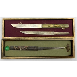 Two Japanese Meiji Kozuka, the first decorated in high relief with Samurai figures in mixed metals with gilt highlights, the steel blade signed, the second having a brass handle relief decorated with fish with two steel blades, unsigned  L21cm , both in display cases (2)