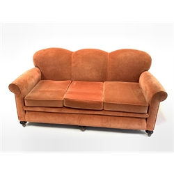 Early to mid 20th century three seat sofa, with serpentine back over loose cushions, raised on turned walnut front supports and replaced castors, upholstered in salmon velvet, W183cm, D95cm