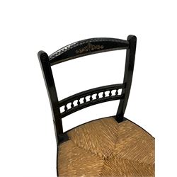 Late Victorian black lacquered low chair, the cresting rail with scrolling decoration, middle rail with turned spindle balustrade, rush seat on turned front supports joined by stretchers