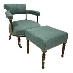 Late Victorian mahogany framed tub chair, the open back and arms upholstered in floral blue fabric, raised on turned supports, together with a similar footstool 