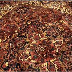 Persian Heriz golden red ground carpet, large floral medallion on field decorated with interlaced foliate, the border decorated with plant motifs