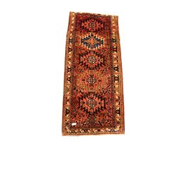 Early 20th century Persian runner rug from the North West region, repeating medallion on red field, geometric design to border 103cm x 245cm 