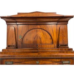 19th century mahogany architectural secretaire a abattant, the top section with projecting cornice over arched panelled door enclosed by applied shaped mounts, the lower section with frieze drawer over fall front, the interior fitted with a drawers and central cupboard, three long drawers below