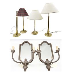 Two pairs of gilt brass table lamps with three shades, H53cm max, together with a pair of cast iron mirror backed two light girandoles with foliate decoration, H61cm